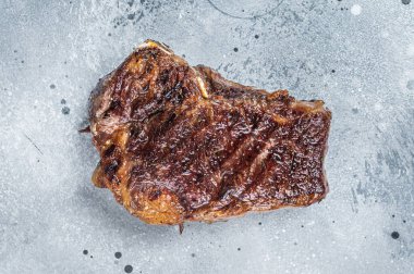 Izgara Striploin bifteği veya New York bifteği. Gri arka plan. Üst Manzara. Boşluğu kopyala.