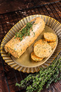 Homemade Herb Butter with thyme. Dark background. Top view.
