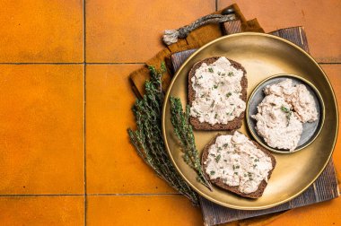 Morina ciğerli tostlar tabağa yayılmış börek. Turuncu arka plan. Üst Manzara. Boşluğu kopyala.