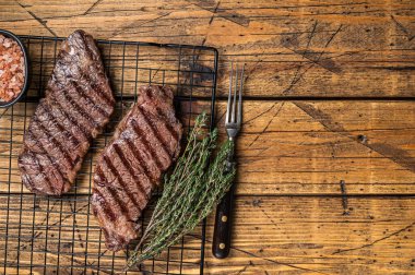 Grilled denver beef meat steak. Wooden background. Top view. Copy space.