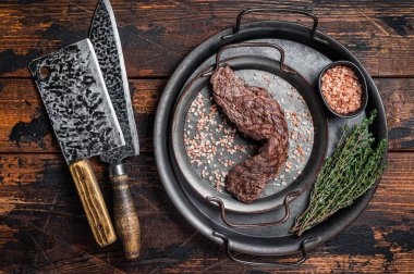BBQ Grilled Machete or skirt beef meat steak in steel tray. Wooden background. Top view.
