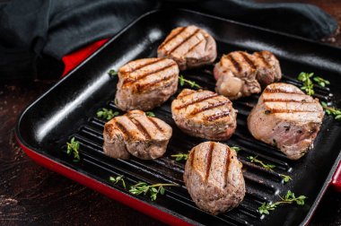 Izgara tavada fileto etinden kızarmış domuz eti bifteği. Karanlık arka plan. Üst görünüm.