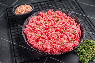 Hamburger köftesi ya da köfte için çiğ kıyma ve domuz eti. Siyah arka plan. Üst görünüm.