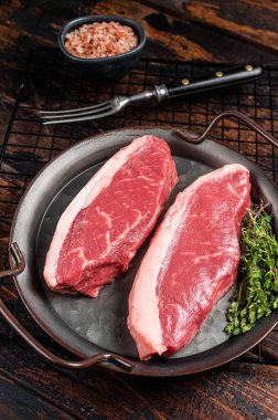 Çiğ sığır filetosu bifteği, baharatlı biftek tepsisi. Ahşap arka plan. Üst görünüm.