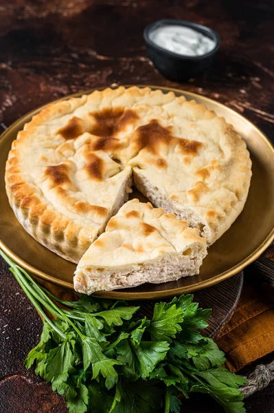 Meat pie Kubdari, Tasty Georgian Flat Bread Stuffed with meat. Dark background. Top view.