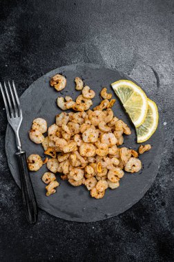 Roast peeled Shrimps prawns with garlic and olive oil, Cocktail shrimps. Black background. top view.