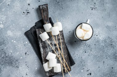 Marshmallow on the stick ready for BBQ. Gray background. Top view.
