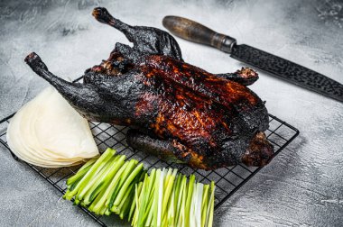 Whole roast Peking duck with herbs, sauce, rice Pancake, Cucumber and onion. White background. Top view.