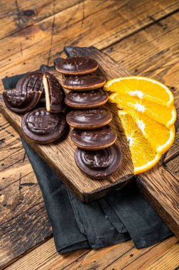 Chocolate Jaffa Cakes with Orange Flavored Marmalade. Wooden background. Top view.