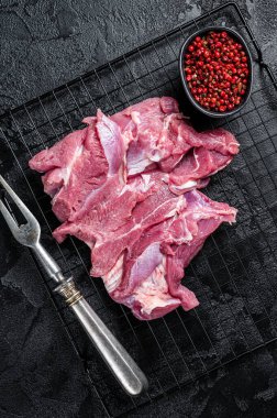 Raw Turkey sliced fillet meat ready for cooking. Black background. Top view.