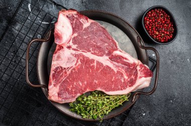 Çelik tepside taze çiğ çiğ et eti. Siyah arka plan. Üst görünüm.