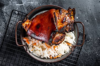 Traditional German cuisine Roasted pork knuckle Schweinshaxe with Sauerkraut. Black background. Top view.