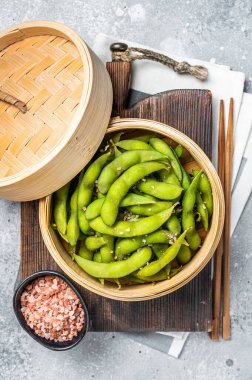 Steamed Edamame Beans with sea salt, soy beans. Gray background. Top view.