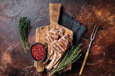 Grilled New Zealand Lamb Chops, mutton cutlets on wooden board. Dark background. Top view.