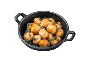 Sarımsak, kekik ve tereyağı ile kurutulmuş deniz tarakları dökme demir tavada servis edilir. İzole, beyaz arkaplan