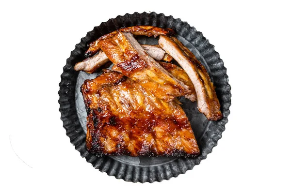 Smoked pork spare ribs glazed in BBQ sauce in a steel plate. Isolated, white background