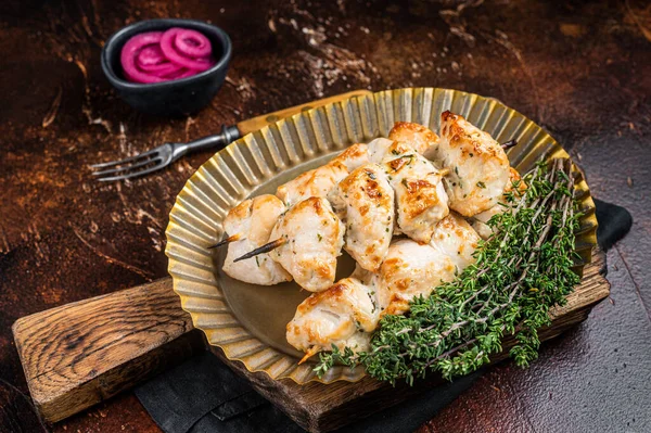 Grilled chicken on bamboo skewers, Shashlik with thyme and spices. Dark background. Top view.