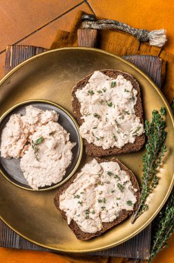 Toasts with Cod liver Spread pate on a plate. Orange background. Top view.