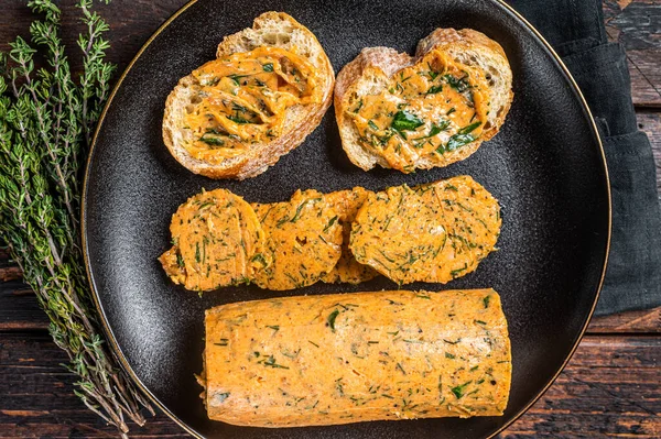 Butter with flavoring additives, sandwich butter with fresh herbs, sweet peppers, lemon, onion, garlic. Wooden background. Top view.