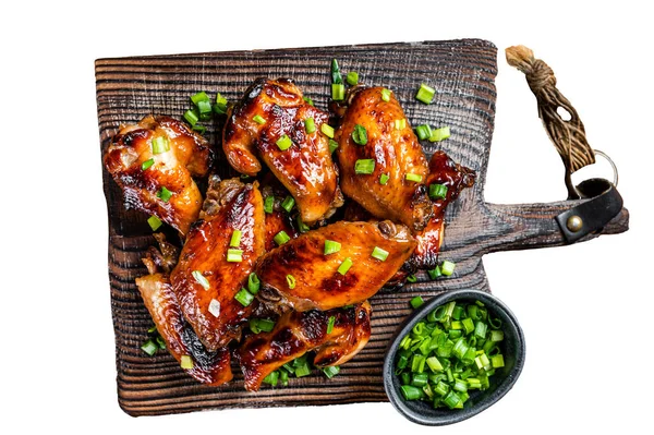 Grilled sweet and sour chicken wings on wooden board. Isolated, white background