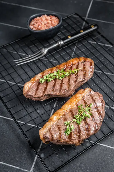 烤好的顶部牛腰肉或杯子牛肉排放在架子上 黑色背景 顶部视图 — 图库照片