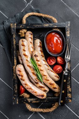 Grilled Bratwurst meat sausages with herbs and spices. Black background. Top view.
