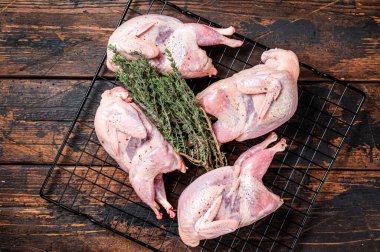 Farm eco friendly raw quails on kitchen table. Wooden background. Top view.