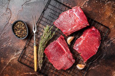 Raw Wild Game Meat of Venison dear ready for cooking. Dark background. Top view.