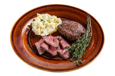 Köy tabağında dilimlenmiş fileminyon ya da bonfile biftek ve patates püresi. Beyaz arkaplanda izole edilmiş, üst görünüm
