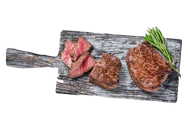Roasted fillet mignon or tenderloin beef steak on wooden cutting board. Isolated on white background, top view