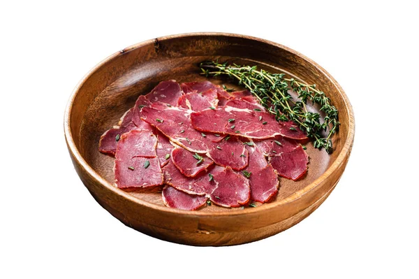 Pastrami slices, dried beef meat with herbs in wooden plate. Isolated on white background, top view