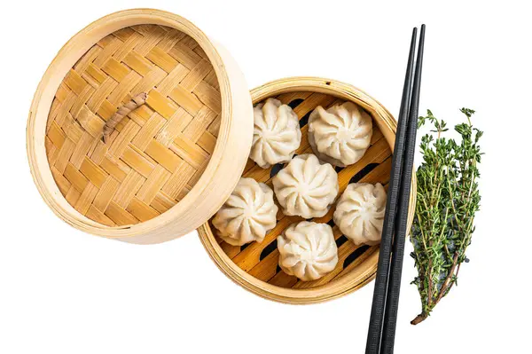Steamed baozi dumplings stuffed with meat in a bamboo steamer. Isolated on white background, top view