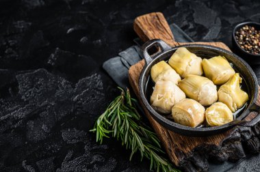 Zeytinyağına bulanmış enginar kalbi otlar ve baharatlarla siyah arka plan. Üst Manzara. Boşluğu kopyala.