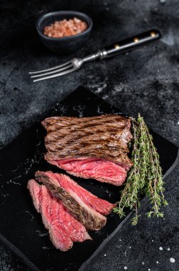 Grilled Wild Venison steak with thyme and salt, game meat. Black background. Top view.
