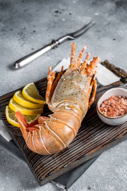 Cooked Spiny lobster or sea crayfish on a wooden board. Gray background. Top view.