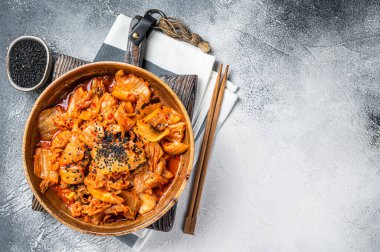 Tahta tabakta kimçi lahanası ve yemek çubukları, Kore mutfağı. Beyaz arka plan. Üst Manzara. Boşluğu kopyala.