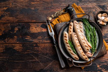 Baharat ve otla kızartılmış sosisler, etli sucuk. Ahşap arka plan. Üst Manzara. Boşluğu kopyala.