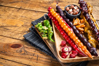 Renkli Churchkhela Gürcistan tatlıları ceviz ve fındıklı. Ahşap arka plan. Üst Manzara. Boşluğu kopyala.