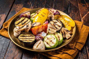 Various grilled Vegetables, bell pepper, zucchini, eggplant, onion and tomato. Wooden background. Top view.