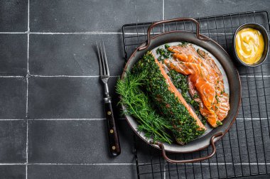 Pickled Salmon fillet with dill, salt and papper, gravlax. Black background. Top view. Copy space.