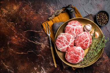 Raw french meatballs cutlet with spices and herbs. Dark background. Top view. Copy space.