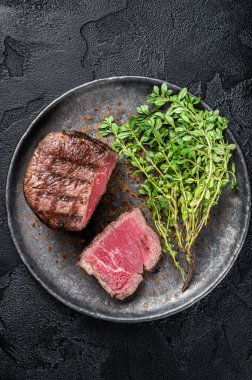 Prime Fillet Mignon Steaks, grilled beef tenderloin meat. Black background. Top view.