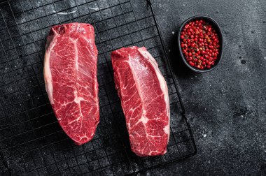 Raw top blade cut organic beef meat. Black background. Top View.