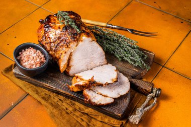 Roasted Pork Meat Roll with garlic sliced on cutting board. Orange background. Top view.