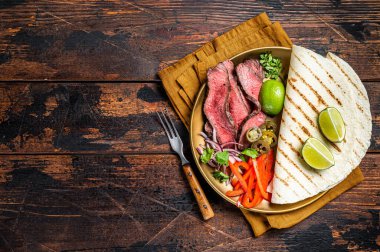 Mexican fajitas for grilled beef steak and vegetables. Wooden background. top view. copy space.