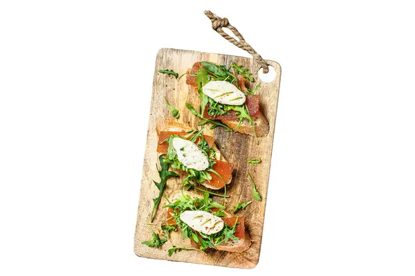 Canapes on a baguette with goat cheese, arugula and pear marmalade. Isolated on white background. Top view