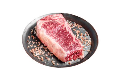 Taze çiğ Wagyu striploin veya çelik tepside otlu New York bifteği. Beyaz arka planda izole edilmiş. Üst görünüm