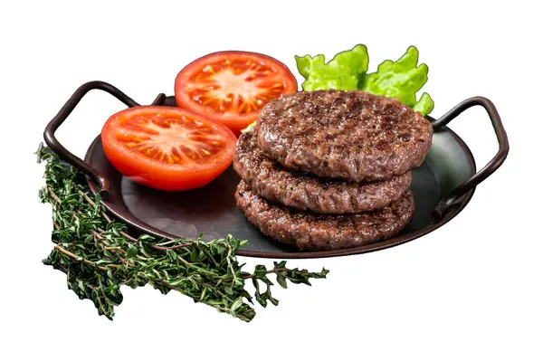 Tasty grilled burger beef patty with tomato, spices and lettuce in kitchen tray. Isolated on white background
