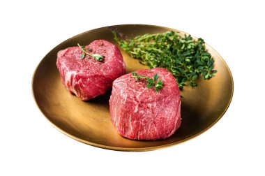 Kurutulmuş fileto Mignon bifteği, bitkilerle, çiğ mermer et. Beyaz arka planda izole edilmiş. Üst görünüm