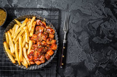 German fastfood currywurst meal, curry wurst with french fry. Black background. Top view. Copy space.